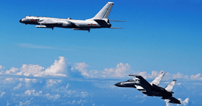 Chinese People's Liberation Army Air Force Su-30 fighter, right, flies with a H-6K bomber duri...png