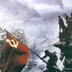 The Soviet flag rises over the German Reichstag in the hands of a Russian e
