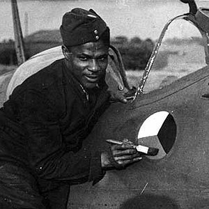 Ground staff paints a Czechoslovak roundel under the cabin of a Spitfire