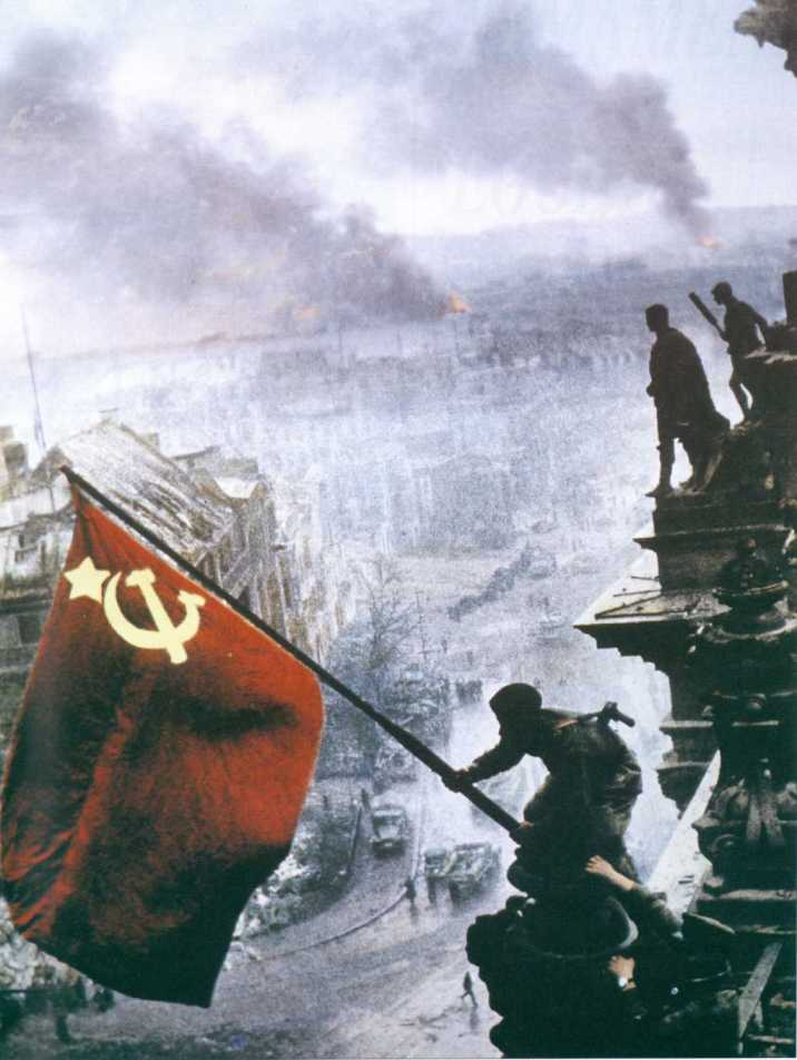 The Soviet flag rises over the German Reichstag in the hands of a Russian e